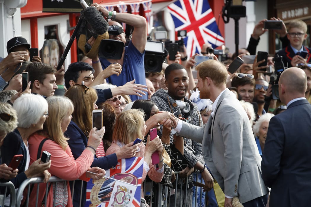 Prince Harry greets well-wishers on the street outside Windsor Castle ahead of marrying Meghan Markle.