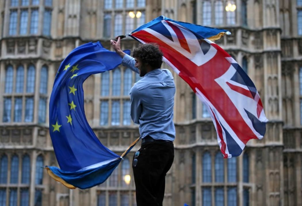 File photo taken on June 28, 2016. A  man waves both a Union flag and a European Union (EU) flag outside The Houses of Parliament at an anti-Brexit protest in central London.