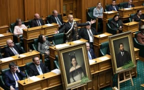 Hamilton West MP Tama Potaka delivers his maiden statement in Parliament with life-size portraits of his ancestors in the foreground, 7 March 2023.