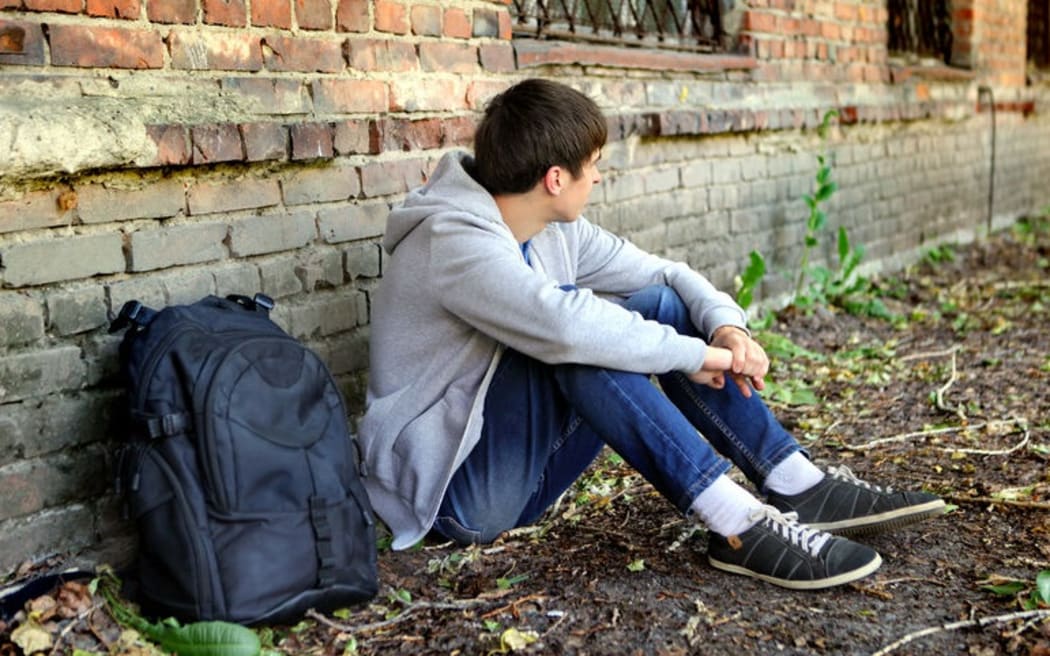 45247047 - sad teenager near the brick wall of the old house