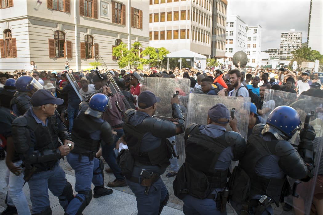 Students from the University of Cape Town clash with members of the South African Police Services after they forced their way into the South African Parliament in Cape Town on October 21, 2015.