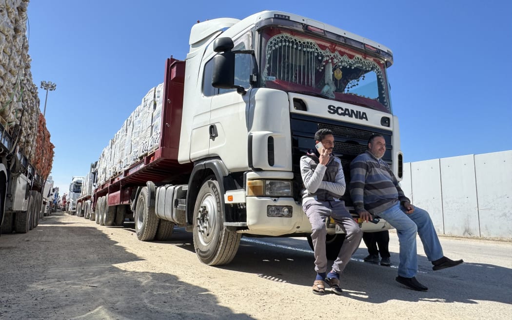 Image depicts trucks carrying humanitarian aid lining up on the Egyptian side of the Rafah border crossing with the Gaza Strip on March 2, 2025, after Israel suspended the entry of supplies into the Palestinian enclave.