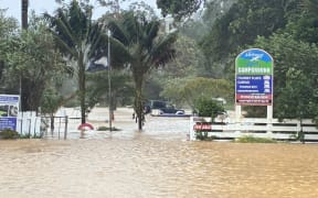 Whitianga Campground is flooded with the water halfway up the doors of vehicles.