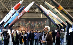 Iranians visit an exhibition showcasing missile and drone achievements in Tehran on November 12, 2025. (Photo by ATTA KENARE / AFP)