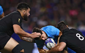 Uruguay's scrum-half Santiago Arata is tackled by Luke Jacobson and Tyrel Lomax (left) during the France 2023 Rugby World Cup Pool A match between New Zealand and Uruguay at the OL Stadium in Decines-Charpieu, near Lyon, south-eastern France, on 6 October, 2023.