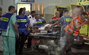 Israeli medics arrive with an injured person at a hospital a few moments after the shooting attack.