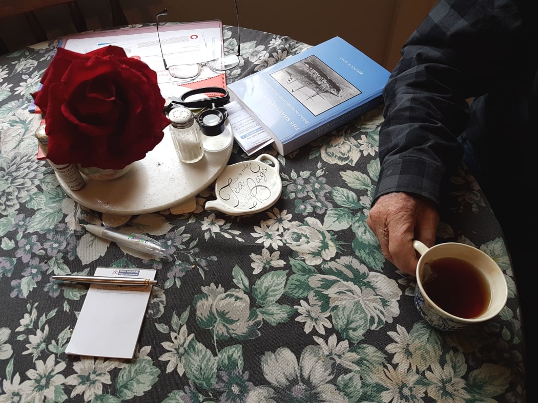 A photo of Baden Norris's kitchen table with book glasses, flowers and a cup of tea
