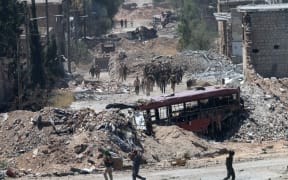 Syrian army soldiers patrol the area around the entrance of Bani Zeid after taking control of the previously rebel-held district of Leramun, on the northwest outskirts of Aleppo.