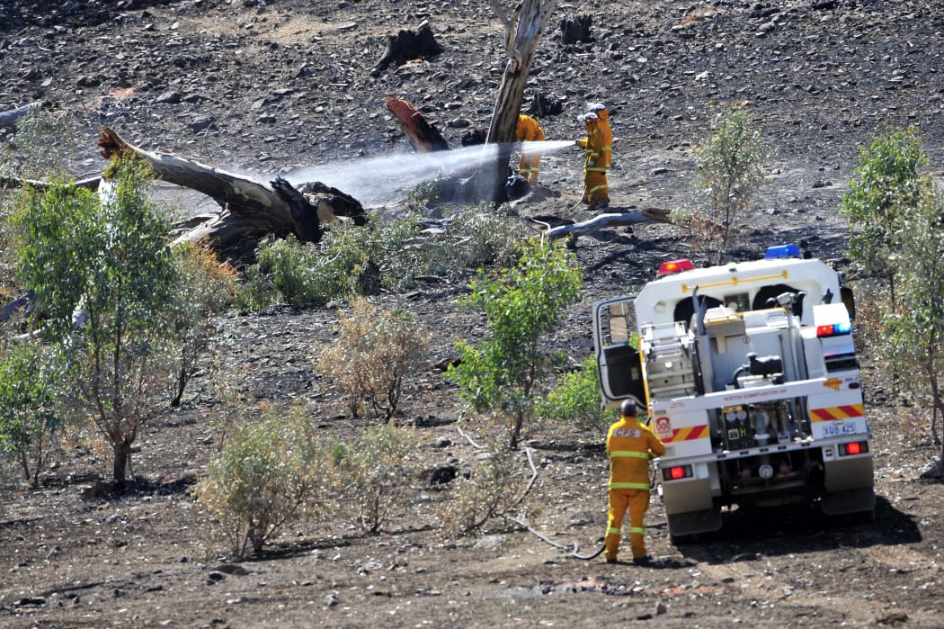 Firefighters put out spot fires near the One Tree Hill area as fires continue to burn through the Adelaide Hills.