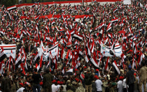 Yemenis waving the national flag during the protest.