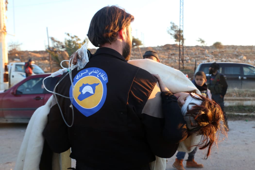 A wounded Syrian, who was evacuated from rebel-held neighbourhoods in the embattled city of Aleppo, is carried by a medic as she arrives in the opposition-controlled Khan al-Aassal region.