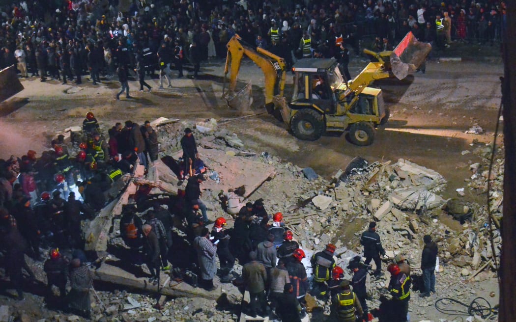 Emergency personnel search for victims in the rubble of two collapsed buildings in the Al Massira area of Fes late on 9 December, 2025.
