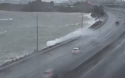 Swells are so large near State Highway 1 in Wellington after Ngauranga interchange that water is hitting passing cars. Lanes have been blocked as a result.