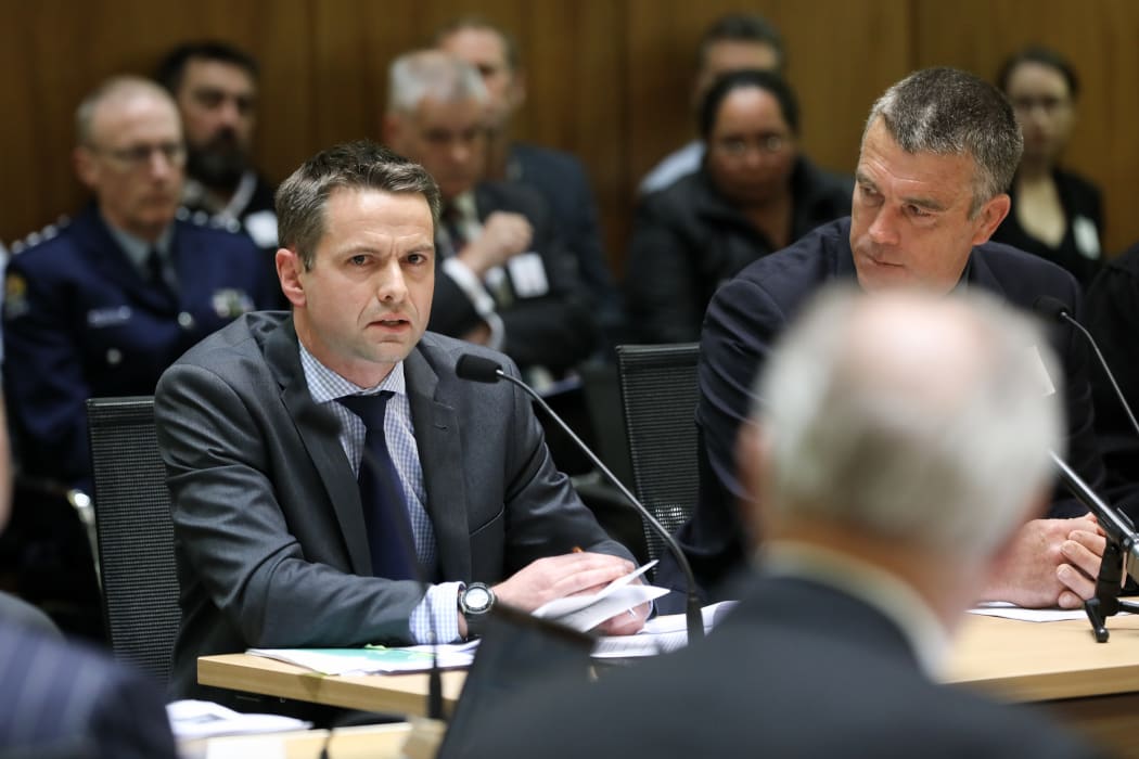 Miles Anderson watches as Ewan Kelsall answers a question from David Carter during submissions on the Arms Legislation Bill