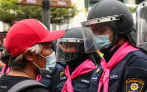 A pro-democracy protester faces off against a police officer in Bangkok on 15 October  2020, after the Thai government banned demonstrations.