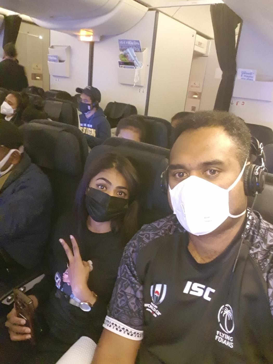 Fijian students Joe Racaca, right, and Sylvia Nandani aboard the chartered Air New Zealand flight from Wuhan.