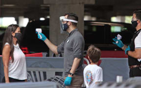 Visitors have their temperatures checked as they arrive at Universal Studios theme park on the first day of reopening after the shutdown during the coronavirus pandemic, on June 5, 2020, in Orlando, Florida.