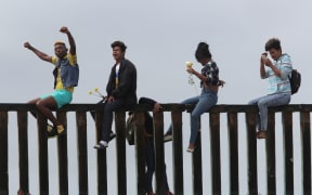 Pro-migrant caravan demonstrators rally on the Mexican side of the border wall on April 29, 2018 in San Diego, California.