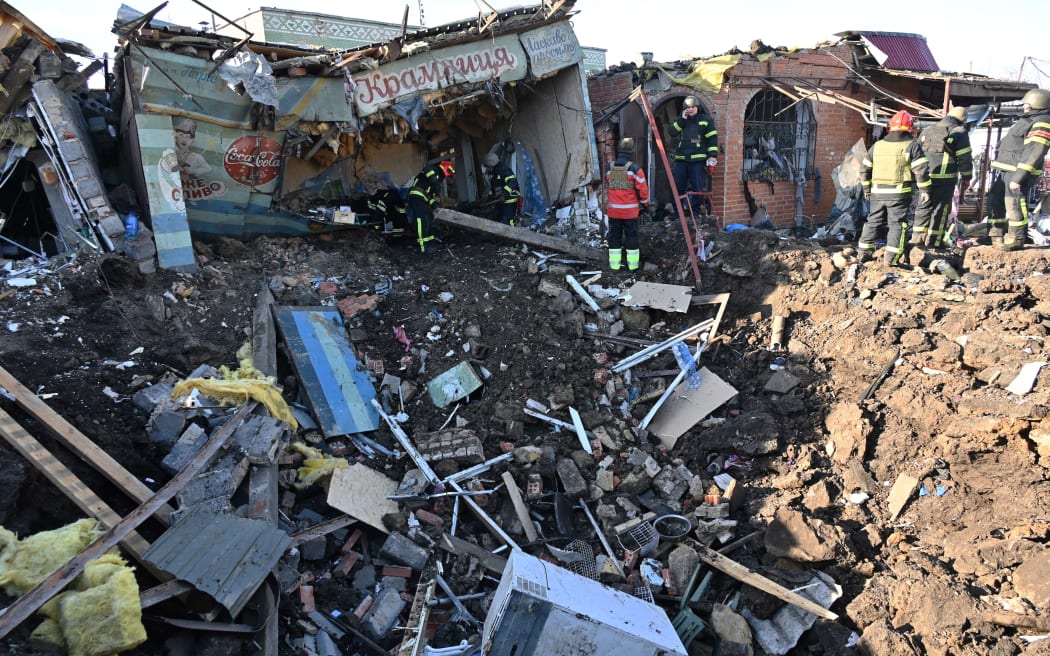 Ukrainian rescuers work on the site following a Russian missile strike on a local market in Shevchenkove village, Kharkiv region on January 9, 2023, amid the Russian invasion of Ukraine. - Oleg Sinegubov, head of the Kharkiv Regional State Administration in his Telegram channel said - according to the updated data of the Regional Center of Emergency Medical Assistance, as a result of an attack by the occupiers on Shevchenkove village, two people were killed. Women in their 50s and 60s. Another 5 people were injured. Among them is a child. (Photo by SERGEY BOBOK / AFP)