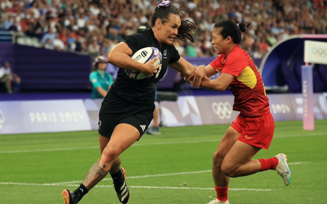 Portia Woodman-Wickliffe shrugs off a Chinese player on her way to the tryline in the Black Ferns quarterfinal win against China at Stade de France.
