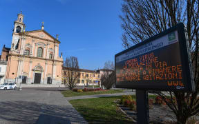A municipal information sign reads "Coronavirus, the population is invited as a precautionary measure to remain at home" is pictured in the village of Casalpusterlengo, southeast of Milan