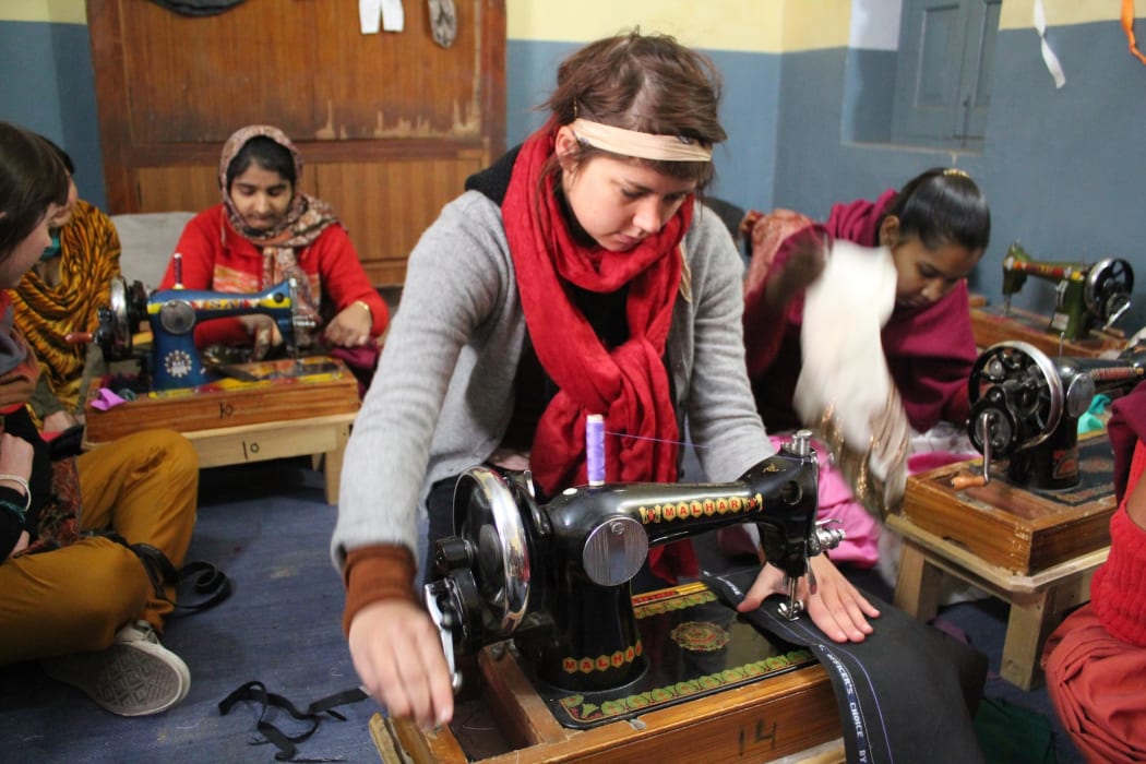 A picture of Annabel Hawkins using a sewing machine in India