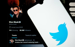 In this photo illustration Twitter logo seen displayed on a smartphone screen with Elon Musk Twitter in the background in Chania, Crete Island, Greece on April 23, 2022. )