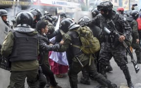 Police Operations Tactical Unit (UTOP) officers scuffle with supporters of Bolivian ex-President Evo Morales during a protest in La Paz.