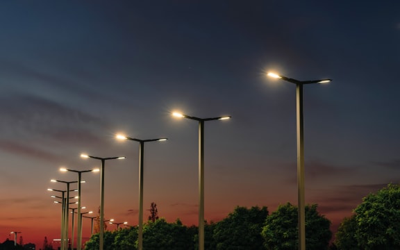 A modern street LED lighting pole. Urban electro-energy technologies. A row of street lights against the night sky.