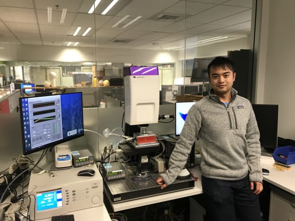Dixon Leung stands next to the profilometer.