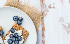 Healthy Snack from Wholegrain Rye Crispbread Crackers with  Ricotta Cheese and Fresh Blueberries on the Light Background
