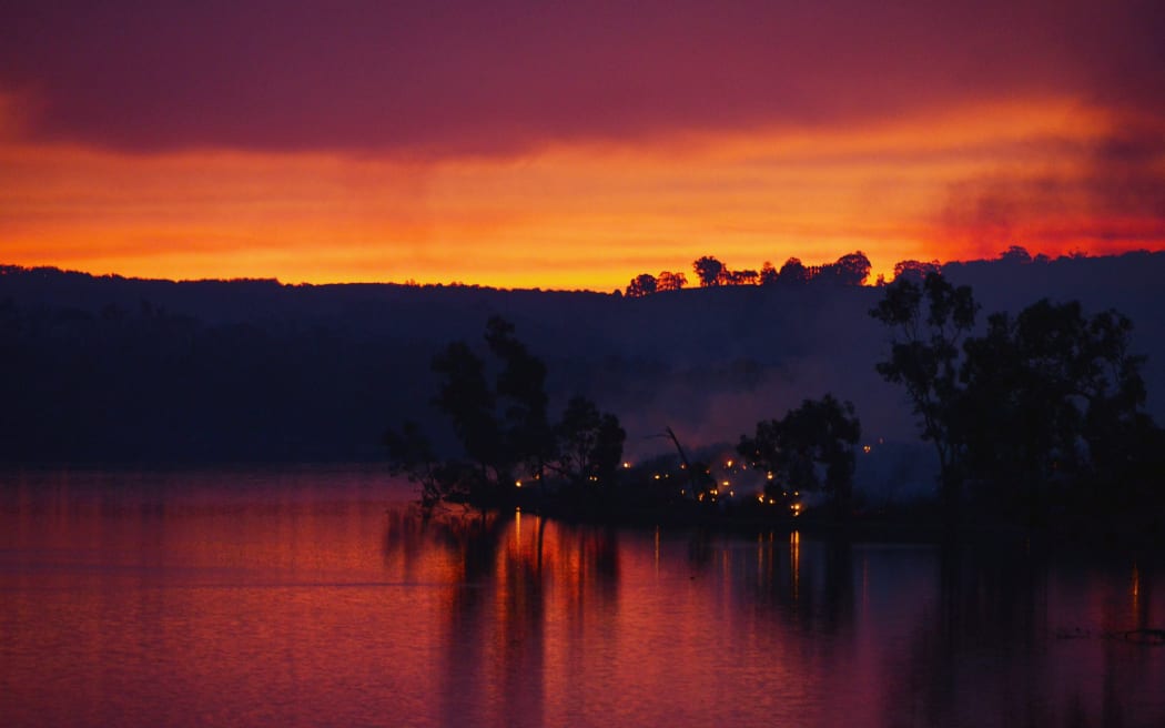 Embers glow against the smoke-filled sunset near Gumeracha in the Adelaide Hills.