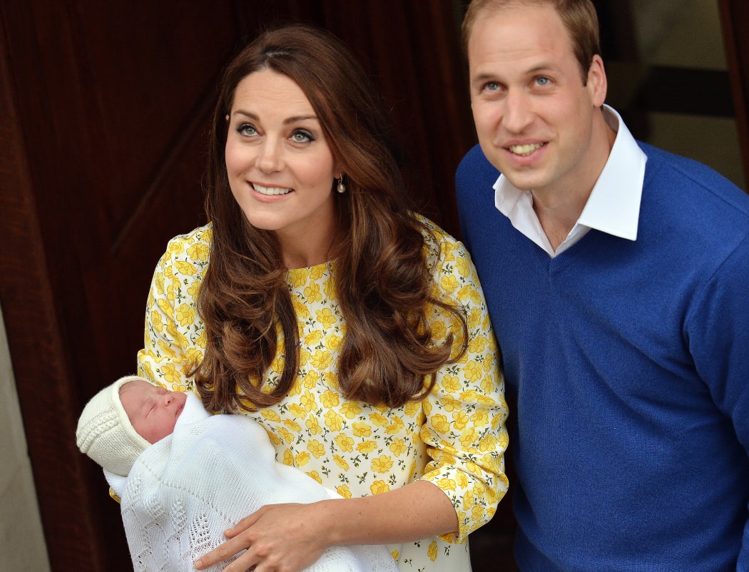 The new parents look up to waiting cameras outside the hospital.