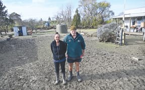 Tokomaru Bay residents Jan and Rick Whaitiri standing in the deluge of mud and silt left behind by severe rain over the weekend.