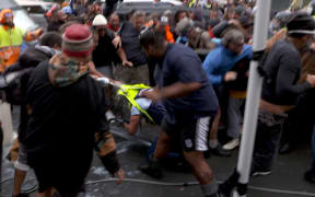 A police officer is dragged to the ground by protestors during police action on March 2nd, 2022.