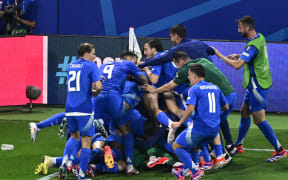 Italy's forward Mattia Zaccagni (unseen) celebrates with teammates after scoring for his team at Euro 2024.