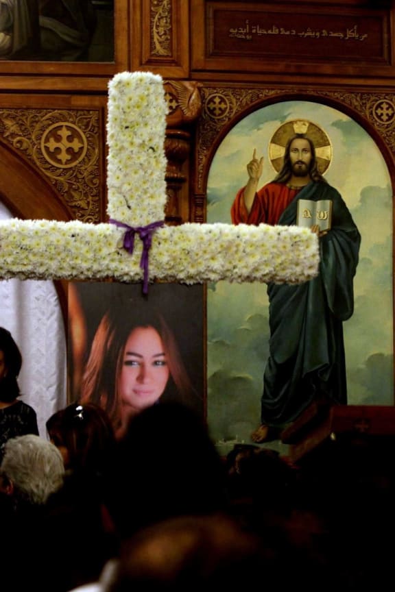 Relatives and friends of EgyptAir hostess Yara Hani (portrait), who was onboard Flight MS804 from Paris to Cairo shortly before it plunged into the Mediterranean, mourn during a ceremony at a church in Cairo on May 21, 2016.