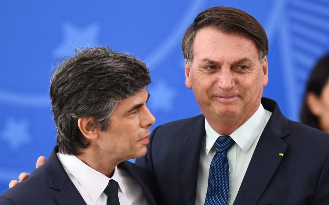 (FILES) In this file photo taken on April 17, 2020 Brazilian President Jair Bolsonaro (R) embraces his new Health Minister Nelson Teich