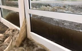 Floodwaters pour into the Milford Visitors' Terminal on Monday