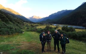 Pauline Dupont and Romain (left) and friends tramping in New Zealand. They emerged from the bush to find the world had turned upside down.