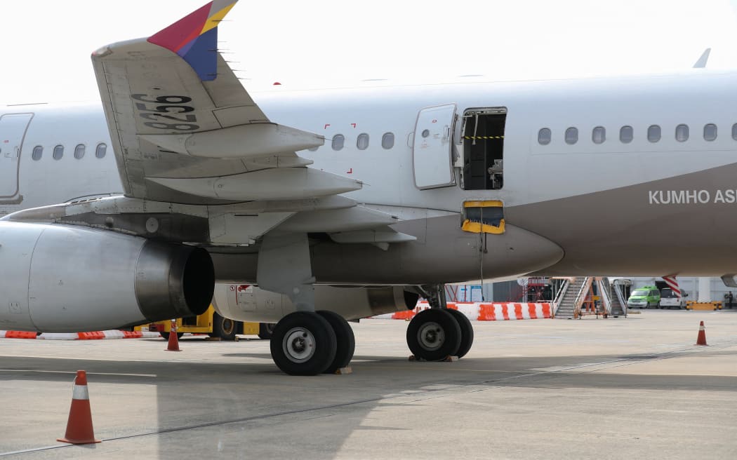 An opened door of an Asiana Airlines plane is seen at Daegu International Airport in Daegu on May 26, 2023, after it was manually opened by a passenger just 200 metres above the ground before landing causing some to have breathing difficulty but with no major injuries. (Photo by YONHAP / AFP) / - South Korea OUT / REPUBLIC OF KOREA OUT  NO ARCHIVES  RESTRICTED TO SUBSCRIPTION USE