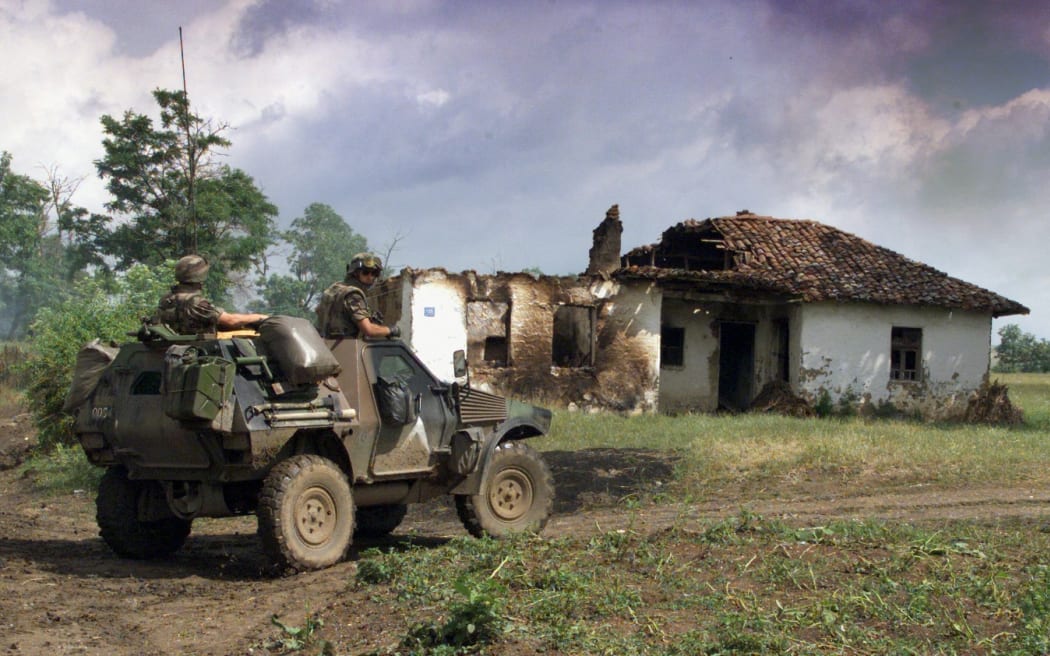 A French armored vehicle patrols in a village abandoned by its inhabitants after the withdrawal of Serb forces from Kosovo in the outskirts of Pristina 21 June 1999. (ELECTRONIC IMAGE) (Photo by JEAN-PHILIPPE KSIAZEK / AFP)