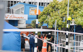 People speak to police at cordon at scene of fatal hit and run in Auckland