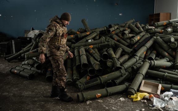 A Ukrainian serviceman of the 93rd brigade stands near a pile of empty mortar shell containers in Bakhmut on February 15, 2023, amid the Russian invasion of Ukraine. (Photo by YASUYOSHI CHIBA / AFP)