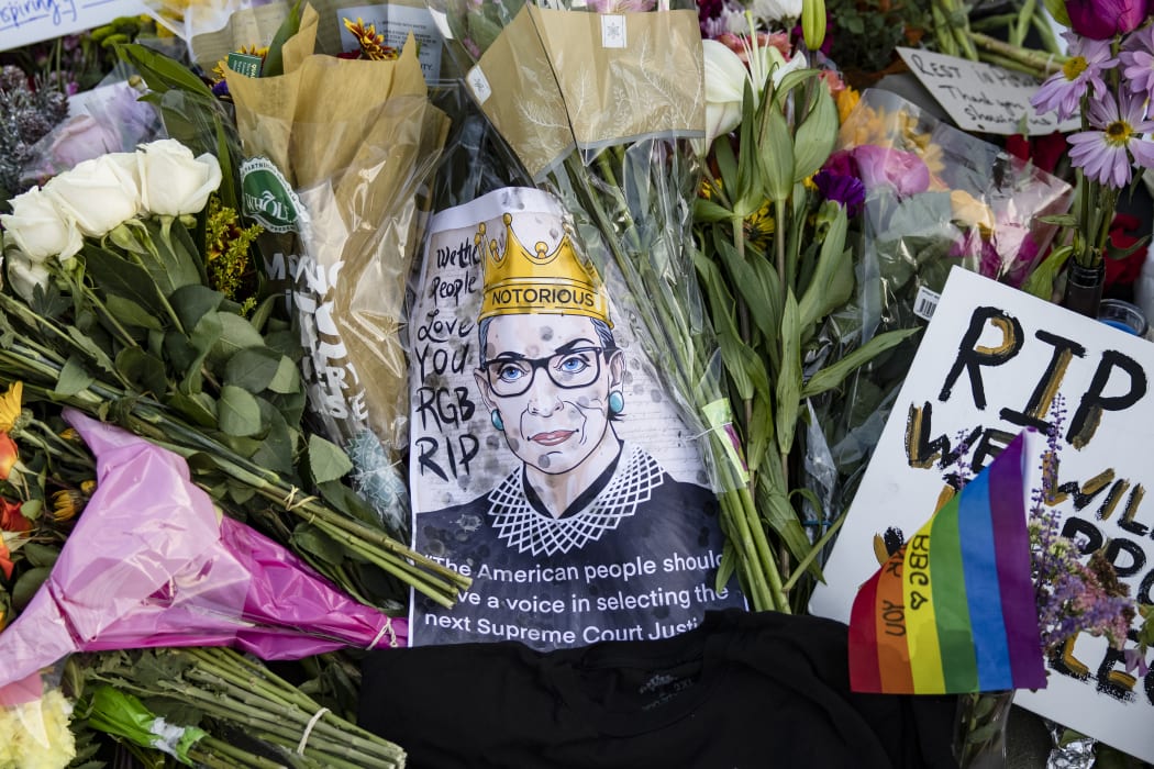 Mourners place flowers, messages, and mementos at a makeshift memorial in honor of Supreme Court Justice Ruth Bader Ginsburg in front of the US Supreme Court