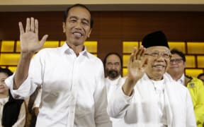 Indonesian President Joko Widodo, left, and his running mate Ma'ruf Amin wave after a press conference in Jakarta, Indonesia, on 17 April, 2019.