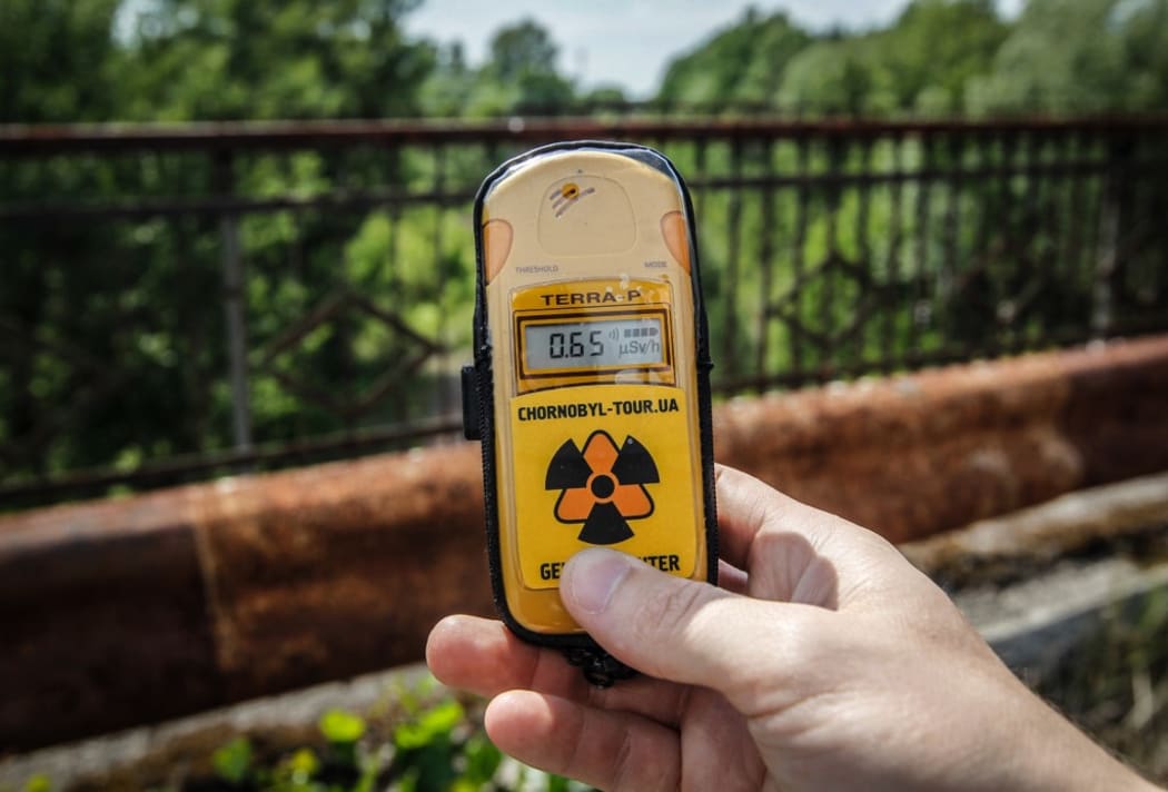 A visitor measures the level of radiation on the so-called Death bridge in the abandoned city of Pripyat, near the Chernobyl nuclear power plant, Ukraine, on 7 June 2019.