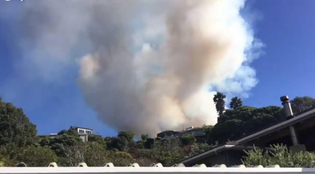 The scene of a blaze moving in on houses at Ahipara. Helicopters have been used tackle the huge bush blaze.