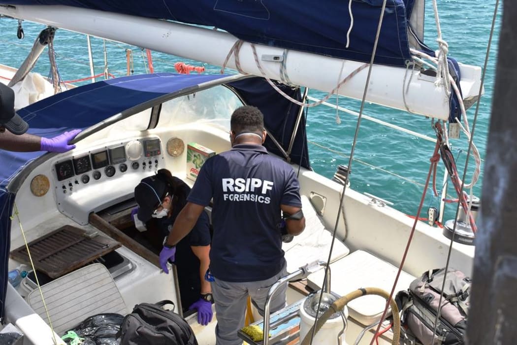Solomon Islands and Australian poilice investigators board the yacht Vieux Malin in Honiara.
