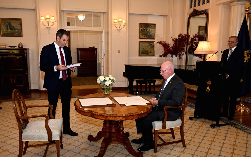 Australia's new treasurer Jim Chalmers (left) takes an oath in front of the Australian Governor General David Hurley and new Prime Minister Anthony Albanese (right), in Canberra on 23 May, 2022.